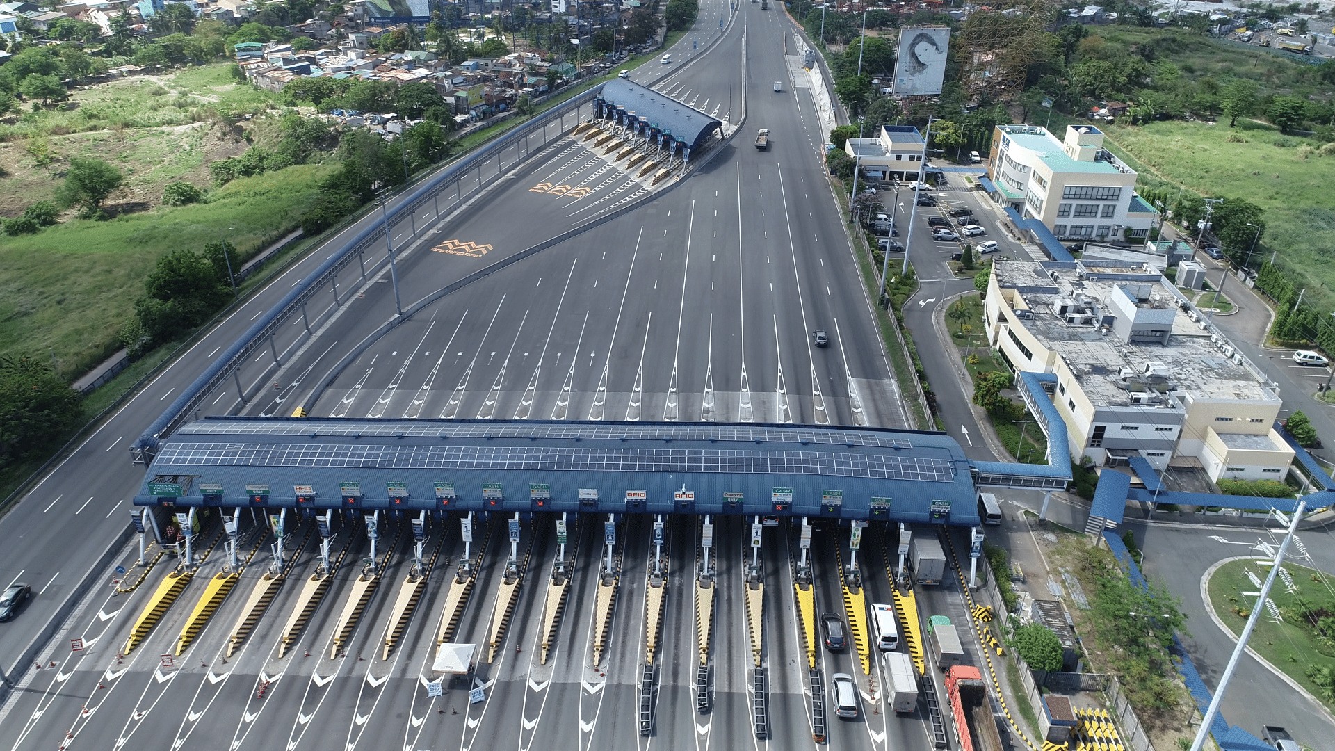 Aerial view of a multi-lane expressway toll plaza with traffic