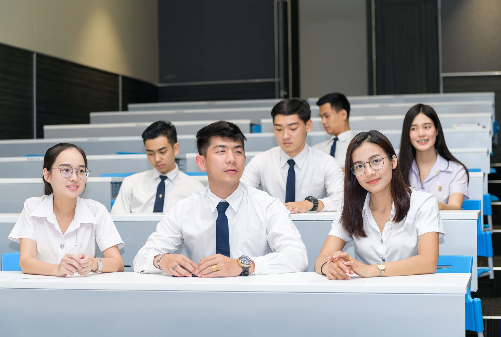 Group of uniformed students seated together in a lecture hall