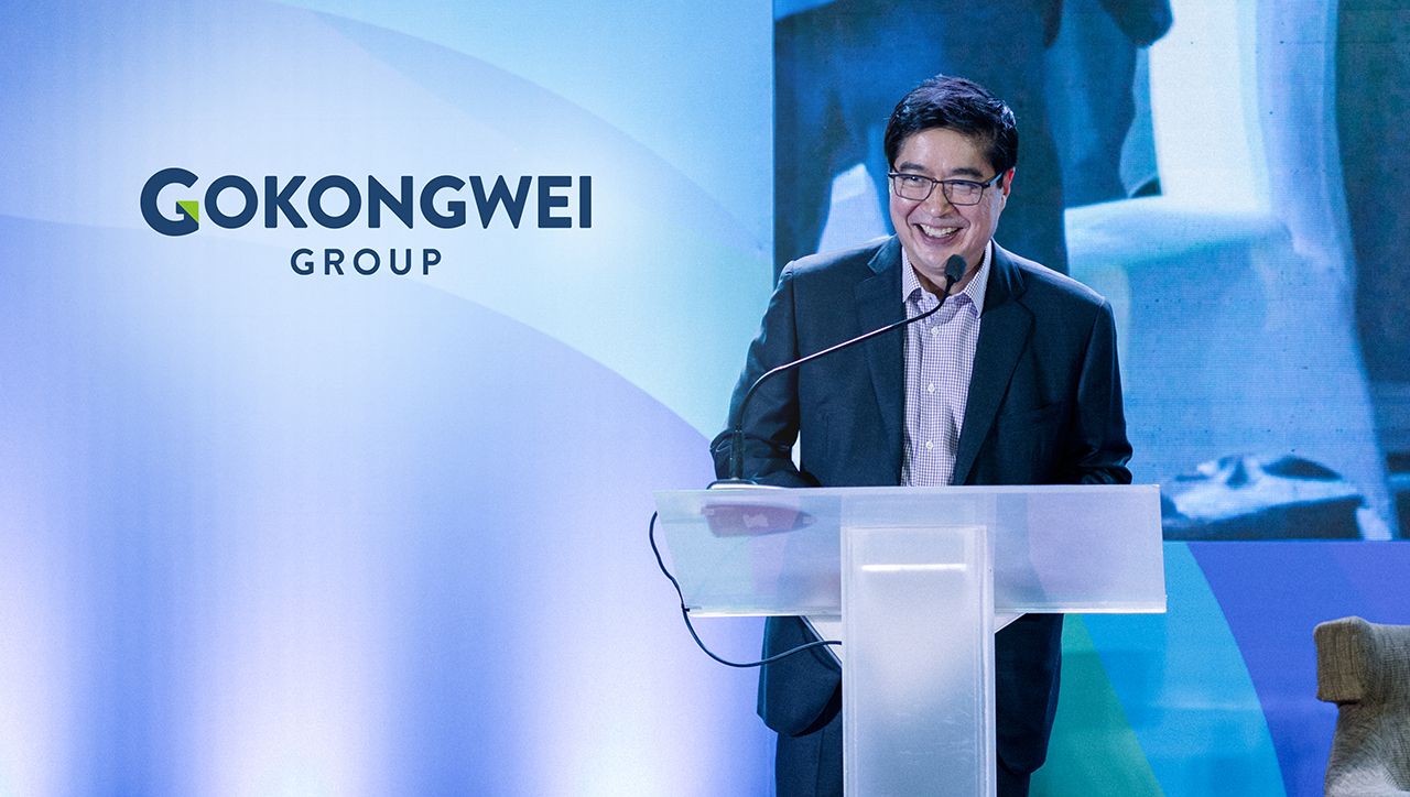Man speaking at a podium in front of a Gokongwei Group backdrop