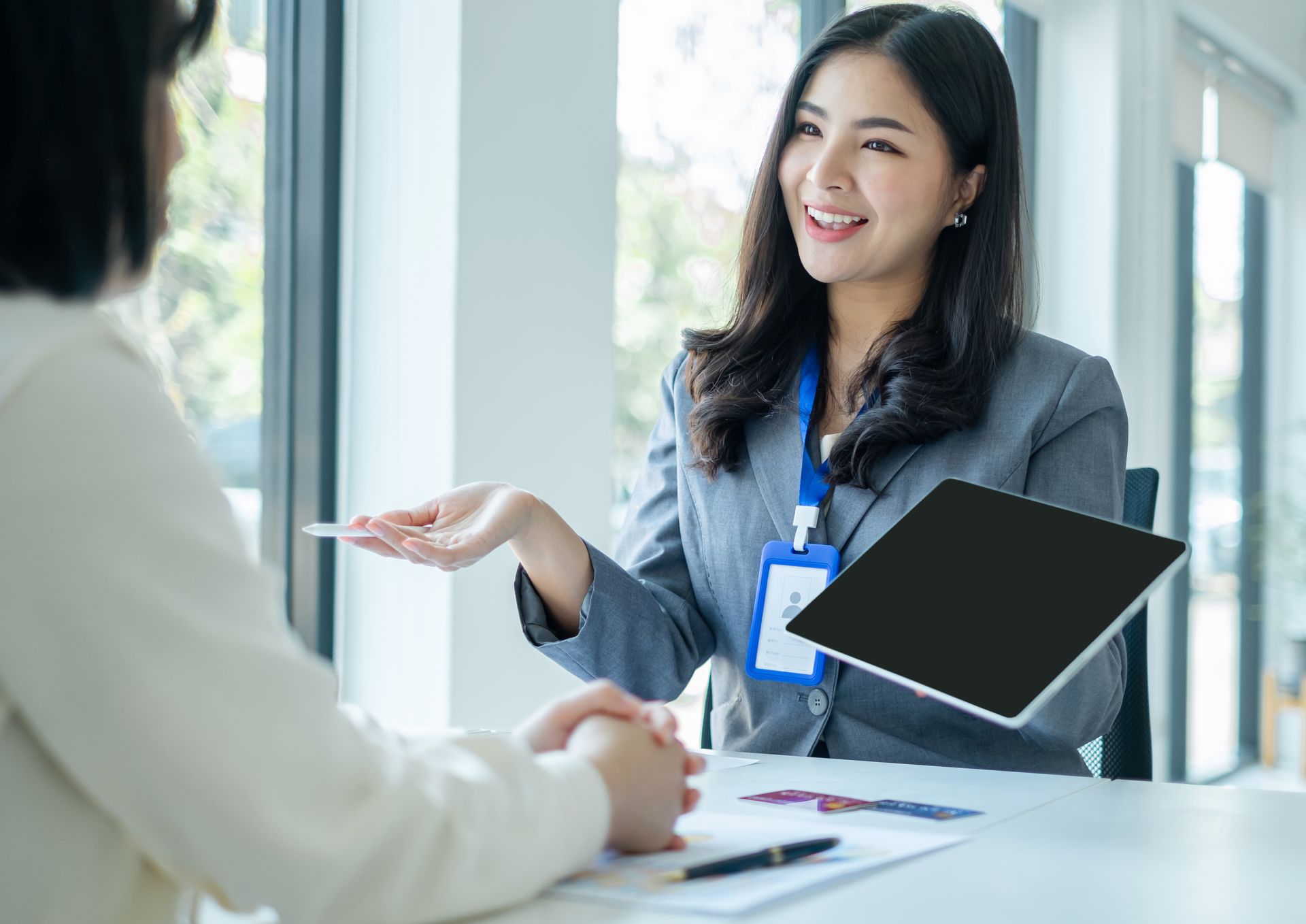 Hand holding a card and phone with digital finance icons and house models