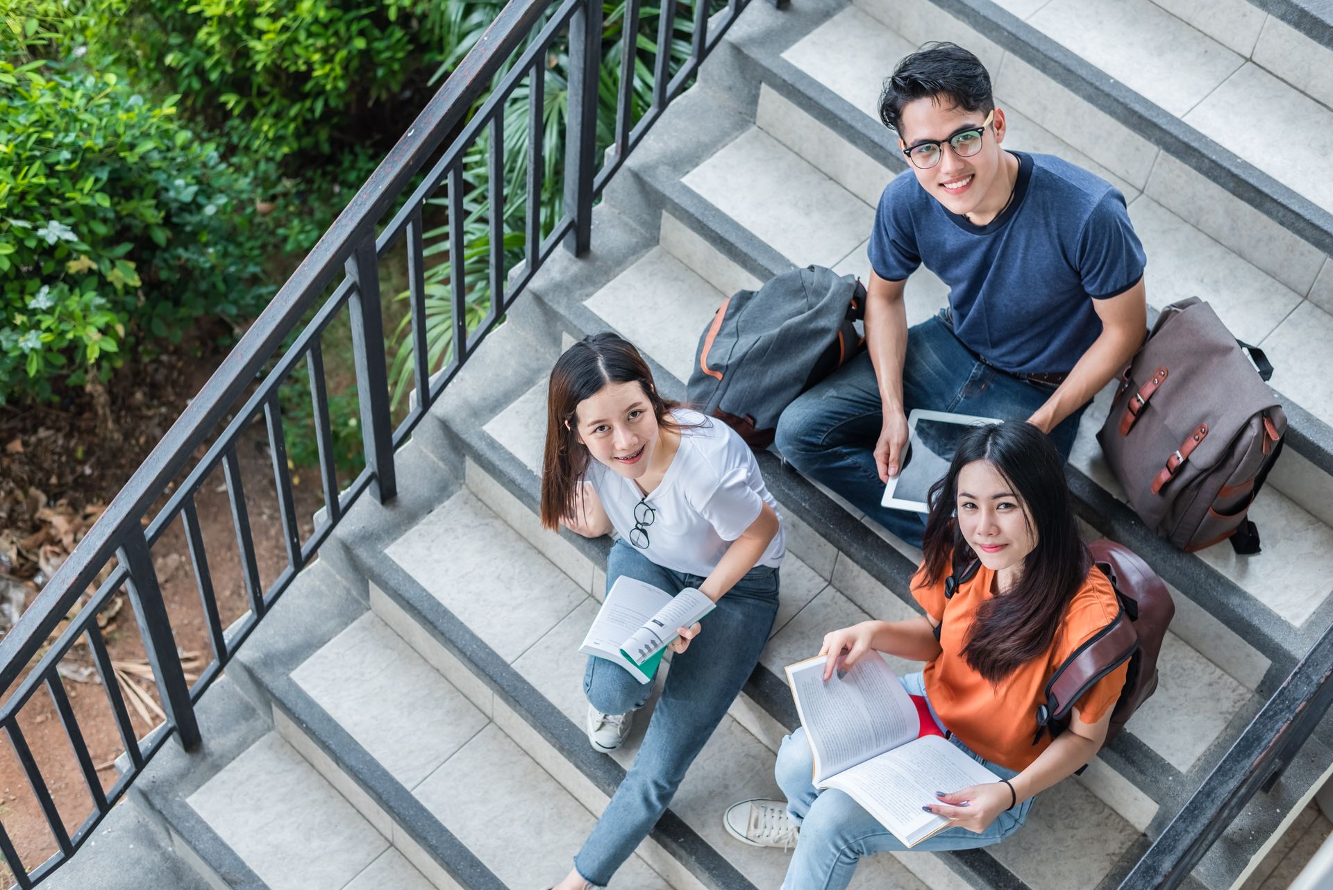 Two students reviewing notes together on a campus walkway