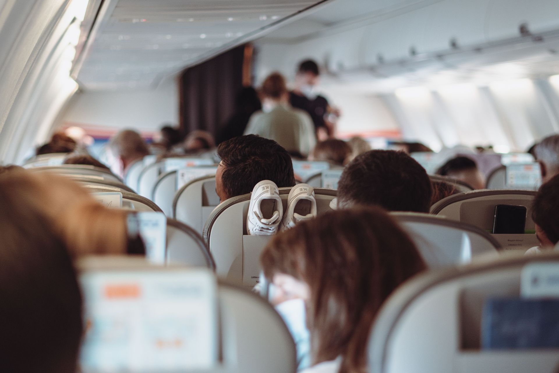 Traveler seated alone at an airport gate watching planes through the window