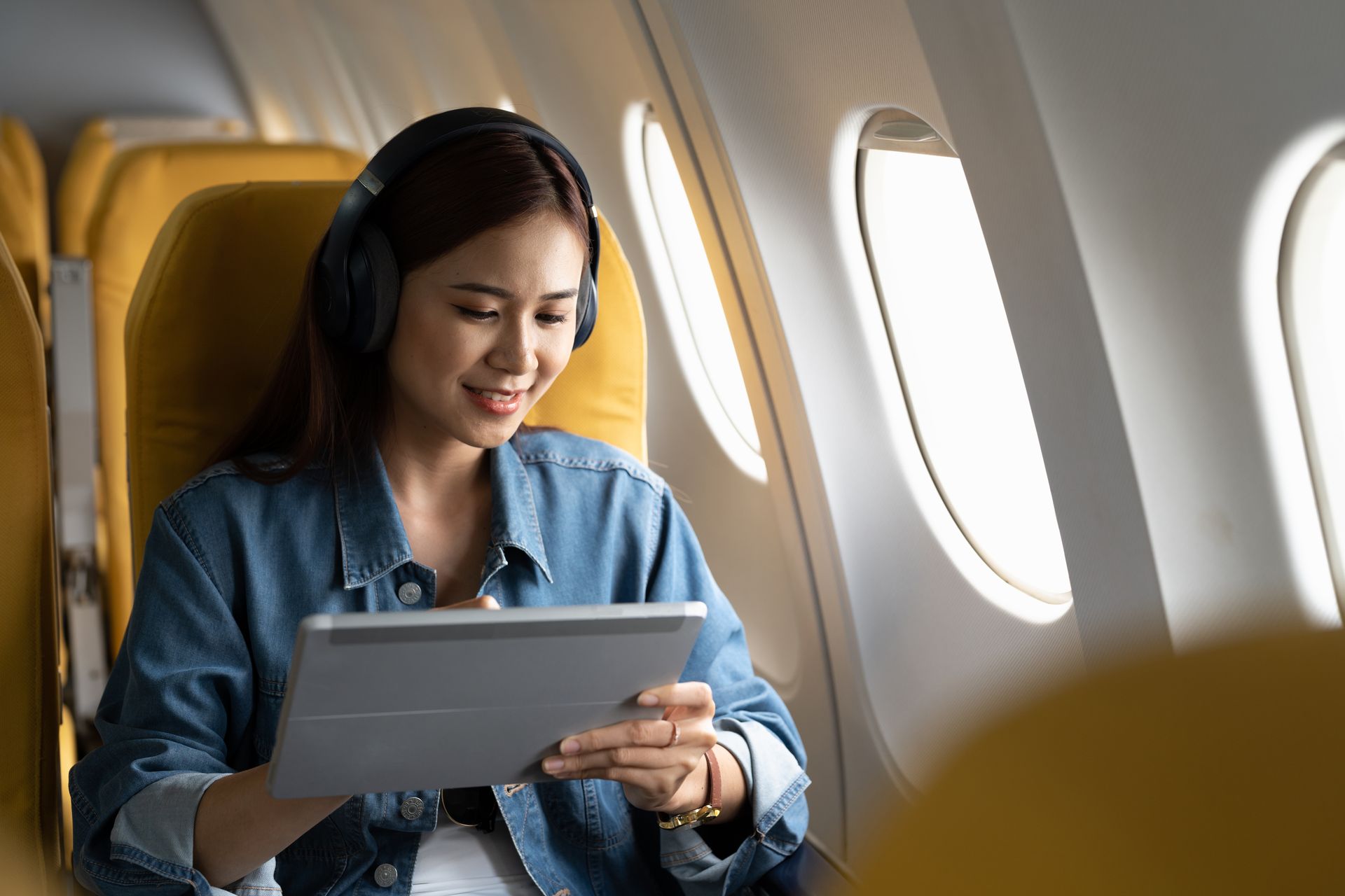 Smiling woman checking her phone while holding a passport in a terminal