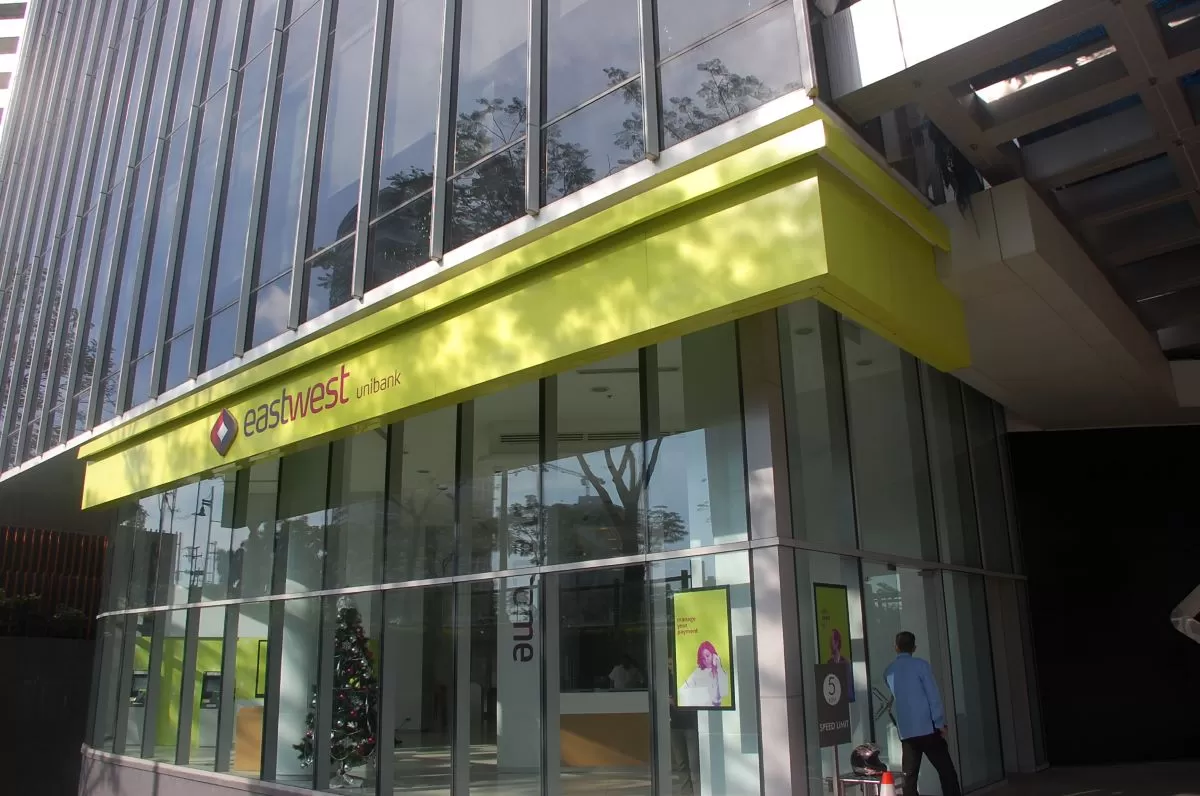 Man walking through a bright EastWest Bank branch lobby