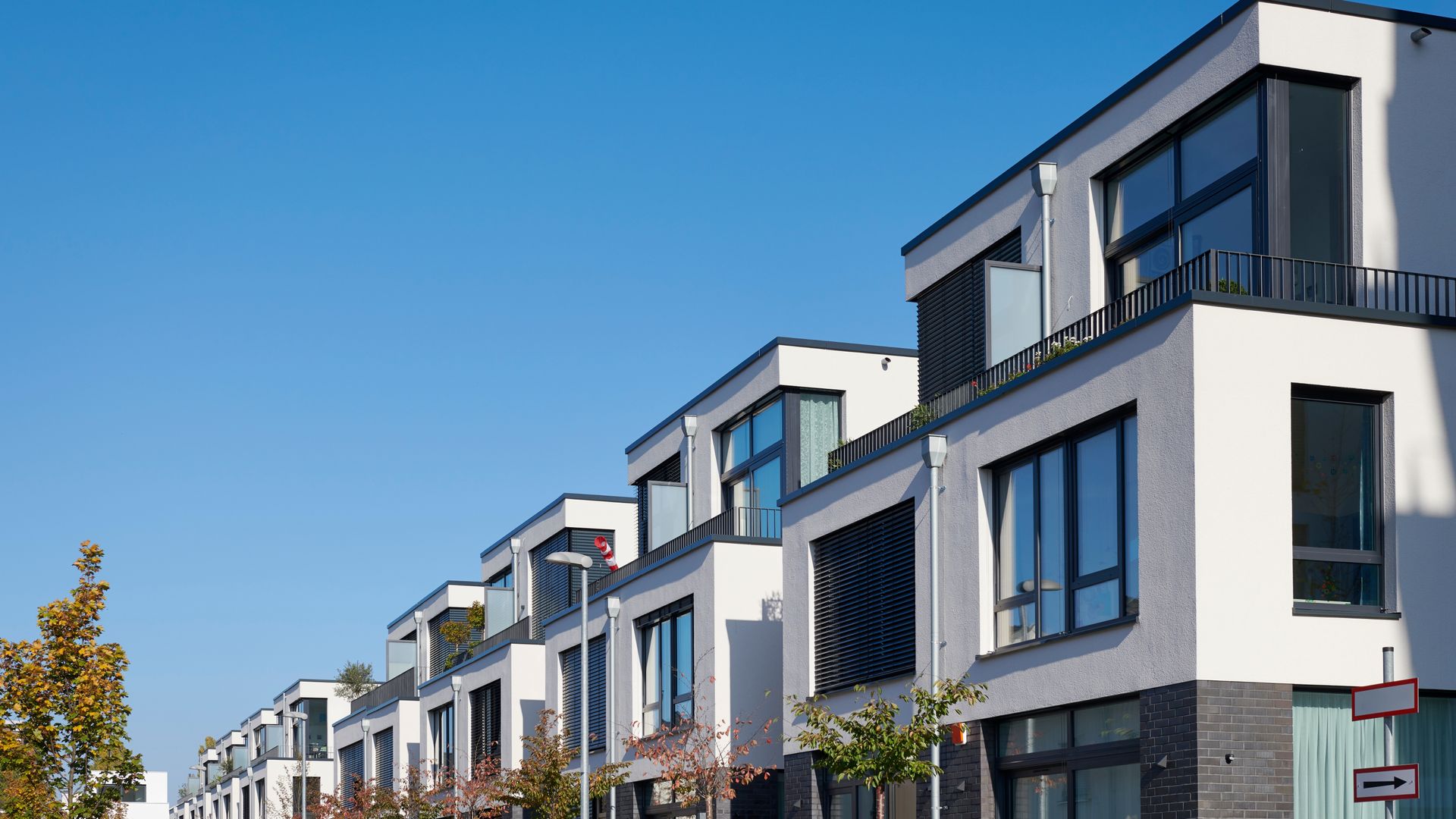 Modern low-rise residential complex with green lawns under a blue sky