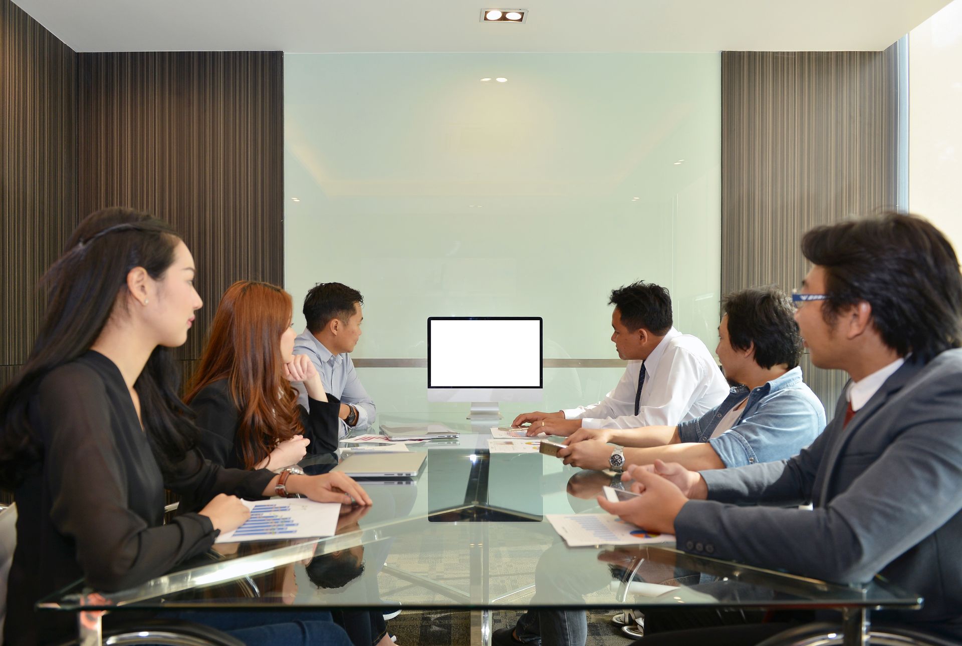 Executives in discussion around a glass conference table