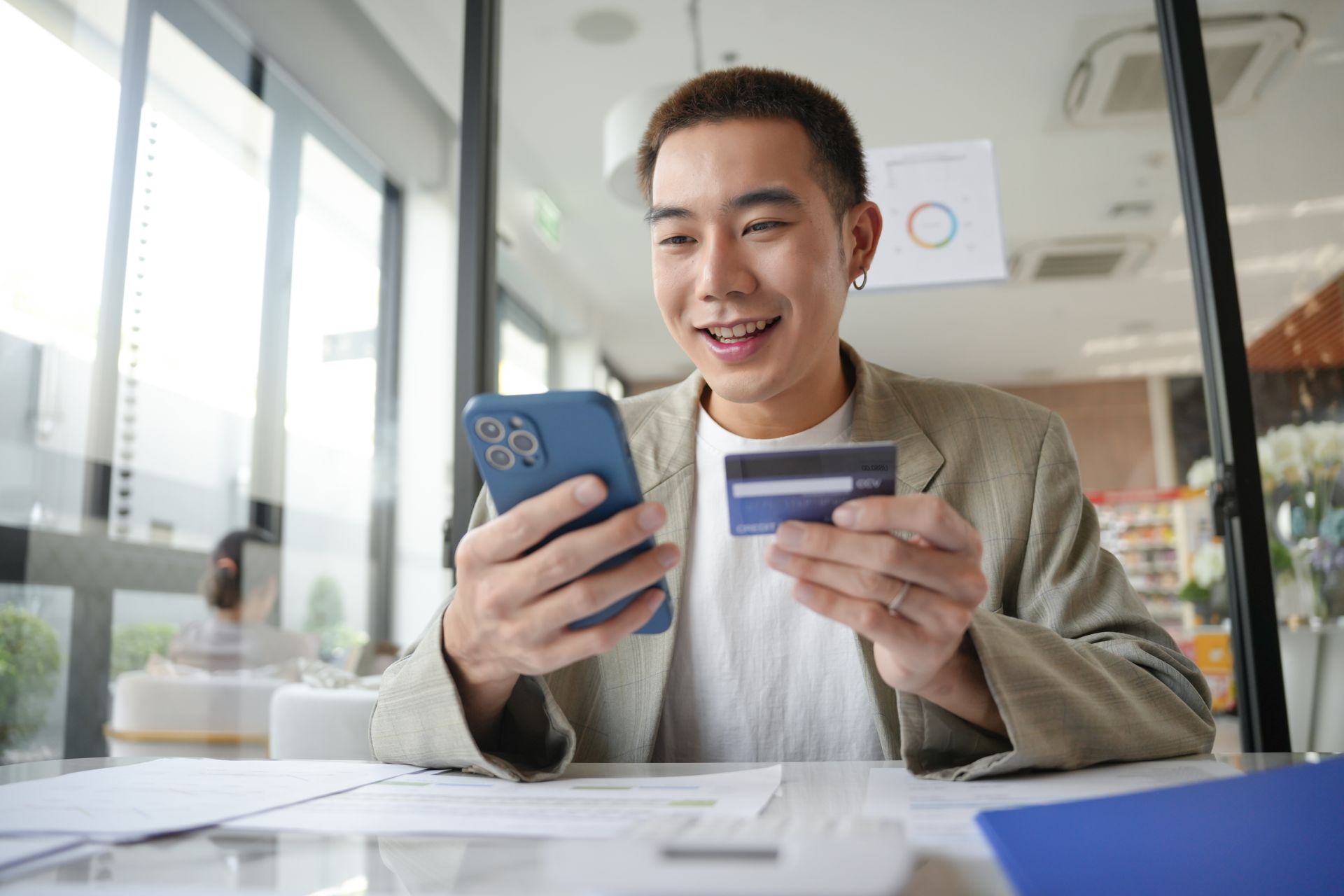Young man smiling while using his smartphone at home
