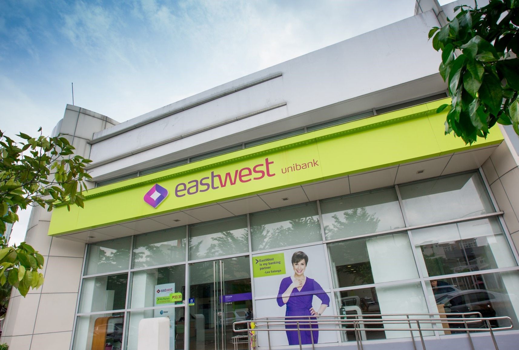 Man walking through a bright EastWest Bank branch lobby