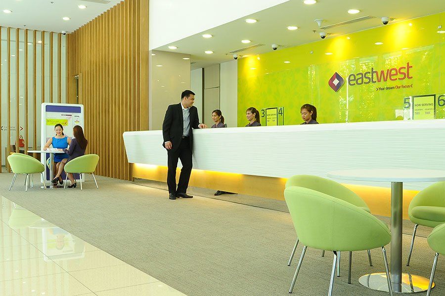 Man walking through a bright EastWest Bank branch lobby