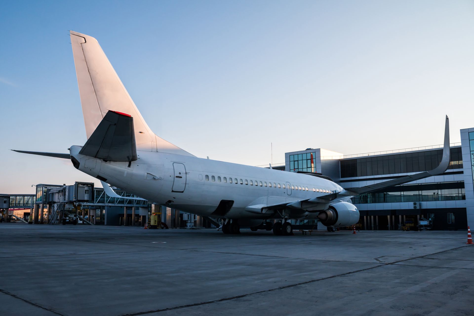 Commercial airplane parked at an airport gate at dusk