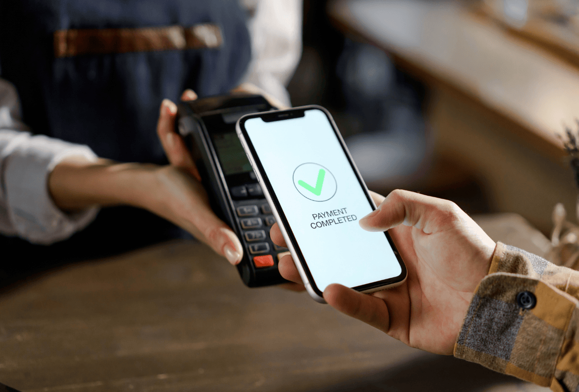 Person holding a smartphone and a debit card