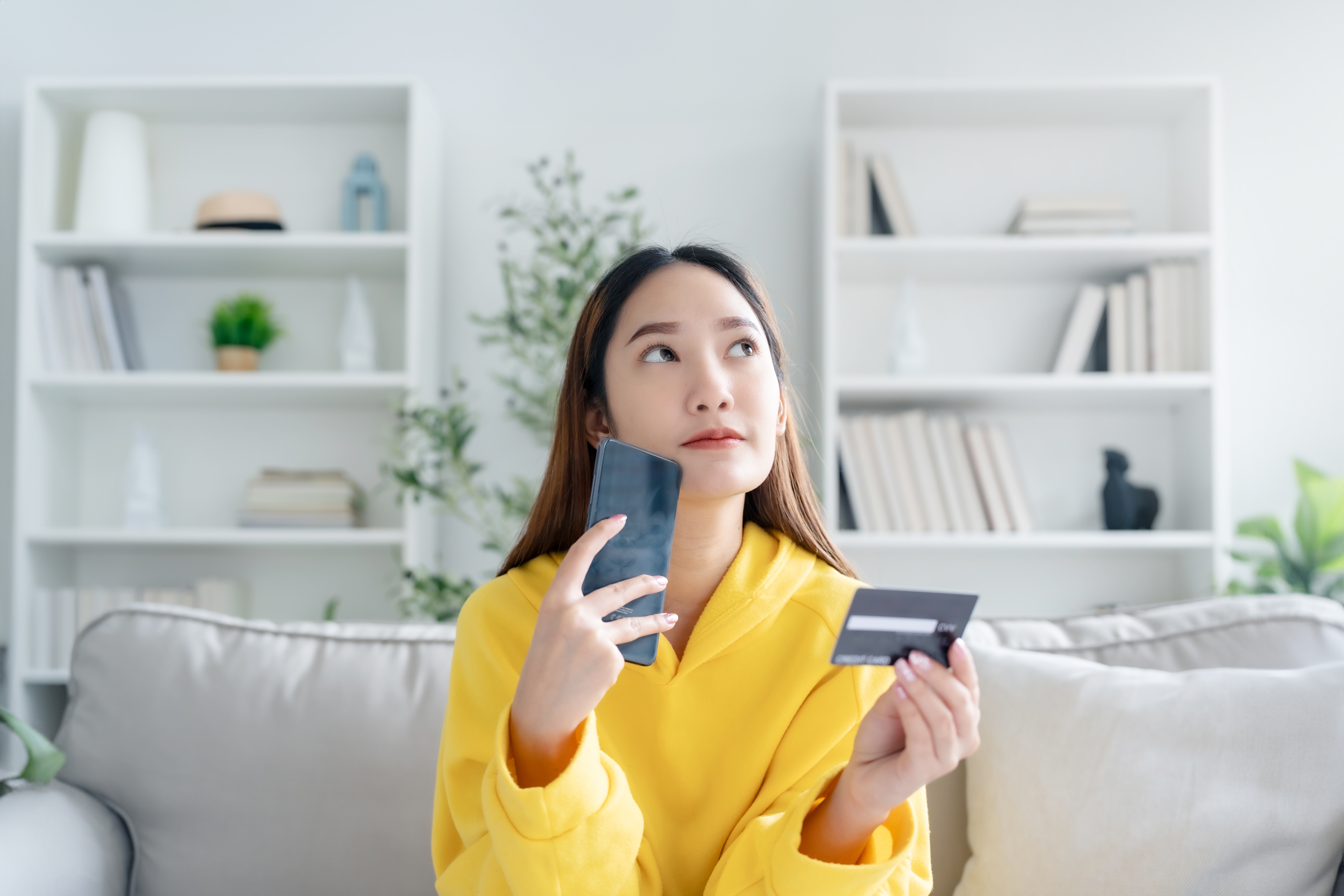 Person holding a smartphone and a debit card