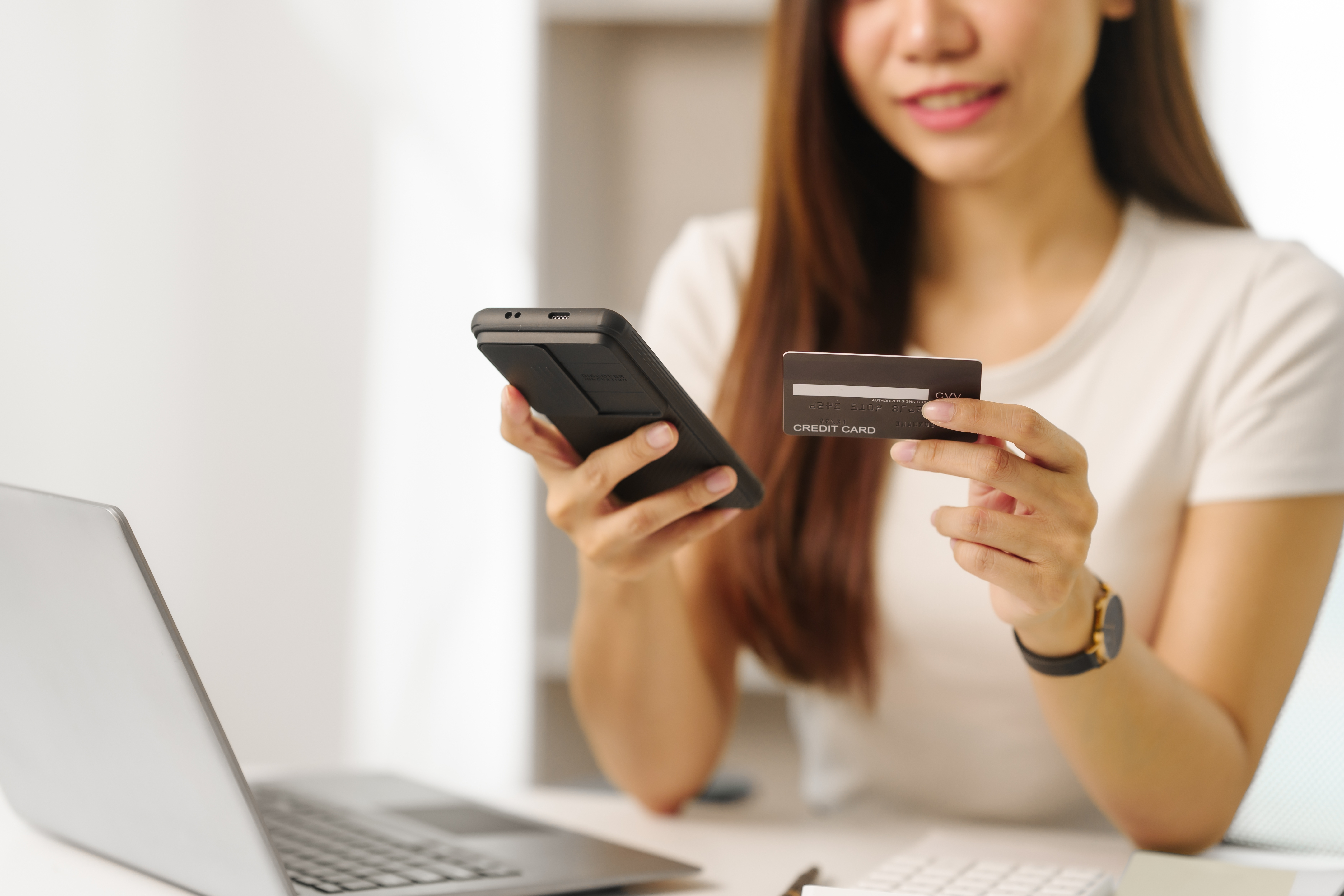 Person holding a smartphone and a debit card