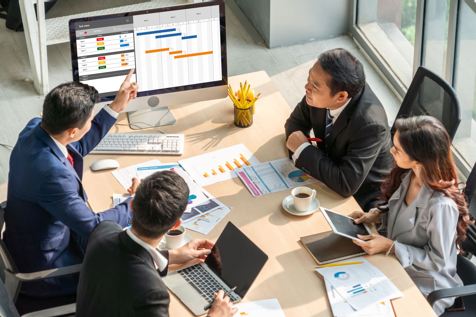 Business team reviewing data on desktop screens in a strategy meeting